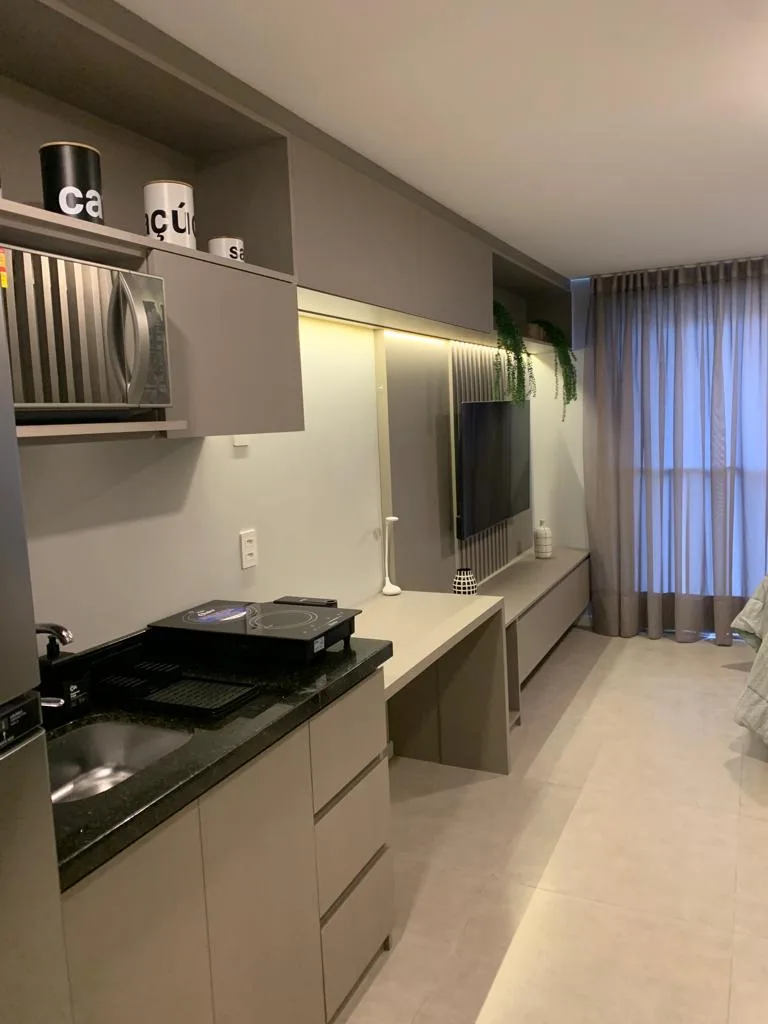 Studio com kitchenette e painel de TV planejados