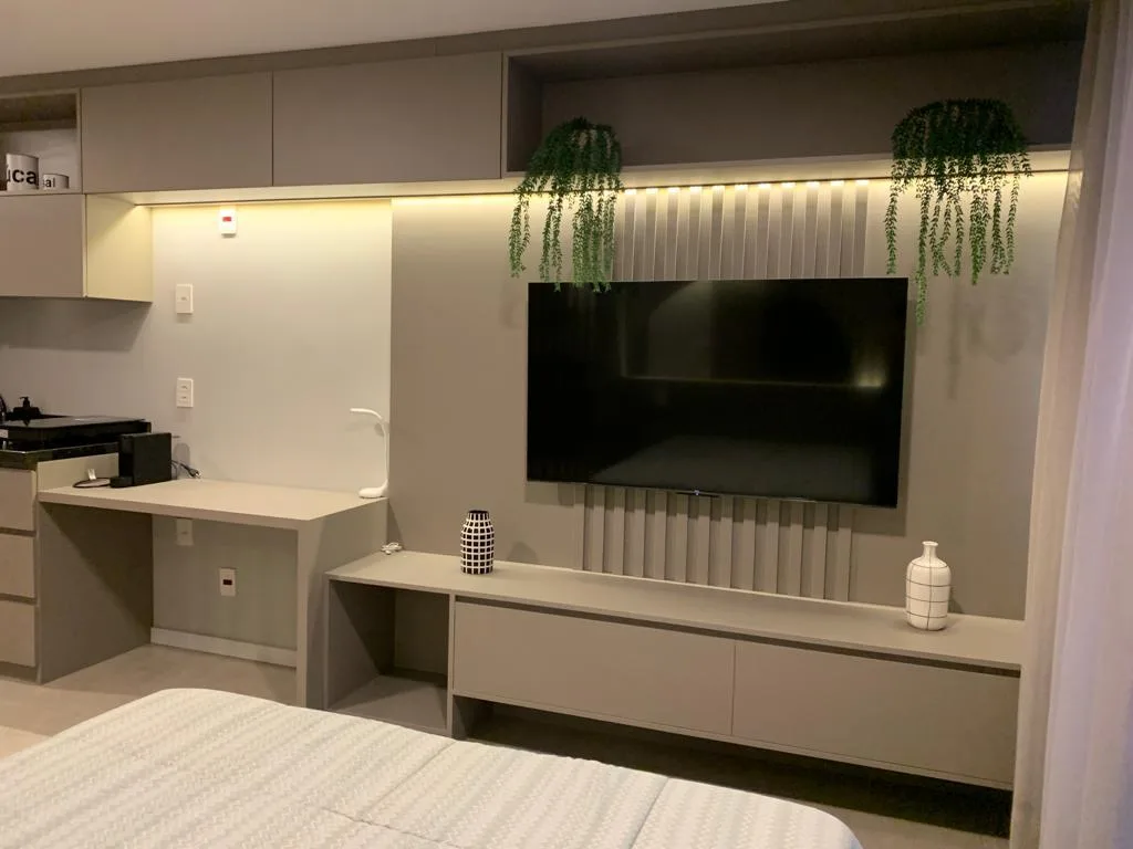Studio com home office, painel de TV e cama planejados