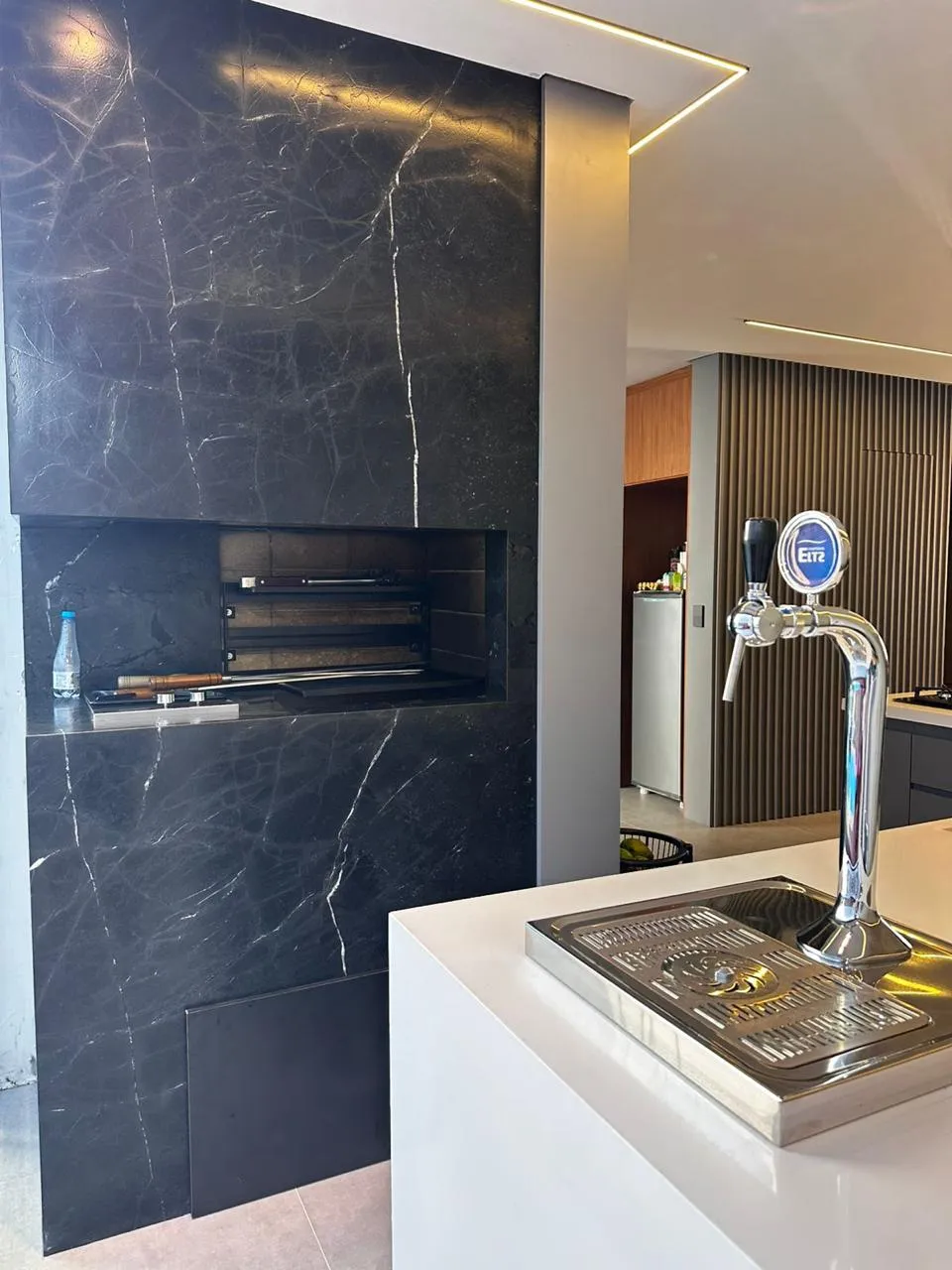 Área gourmet com churrasqueira em mármore e ilha